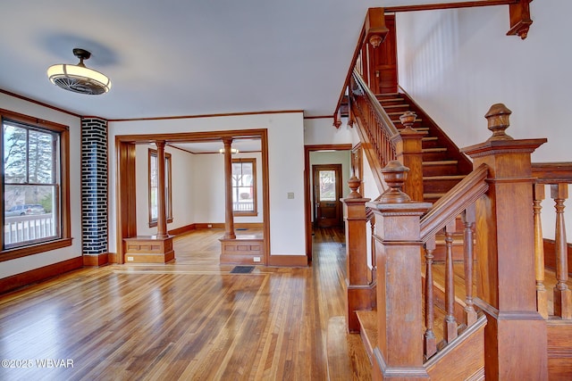 entrance foyer with plenty of natural light, baseboards, ornamental molding, and wood finished floors
