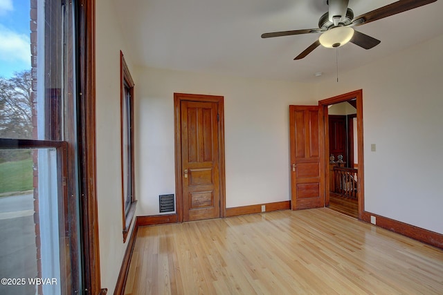 unfurnished bedroom with light wood-style floors, visible vents, baseboards, and multiple windows