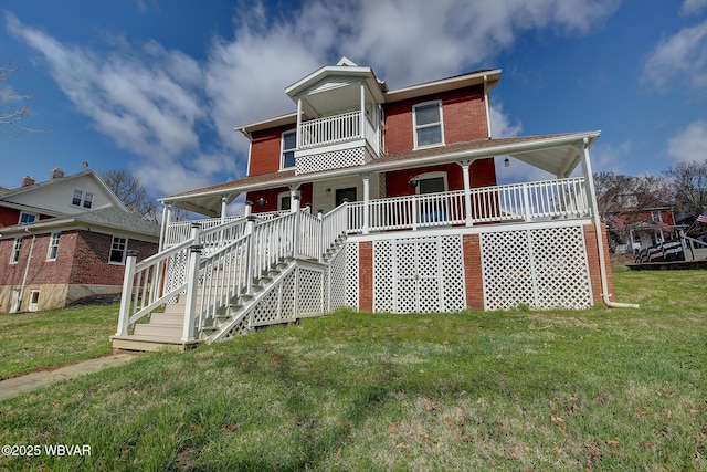 view of front of home with a front yard, stairway, and covered porch