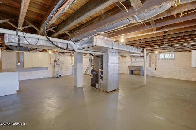 basement featuring heating unit and water heater