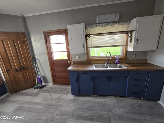 1013 Allegheny St, Jersey Shore, PA 17740 - kitchen with a sink, blue cabinetry, ornamental molding, light wood-type flooring, and white cabinetry