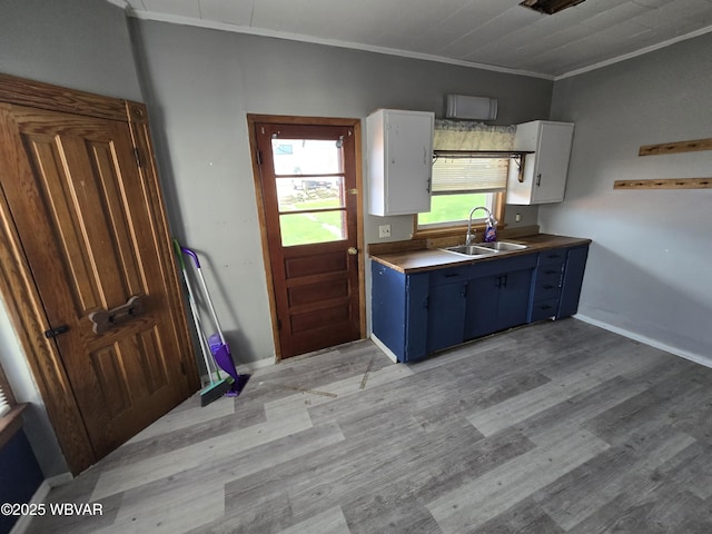 1013 Allegheny St, Jersey Shore, PA 17740 - kitchen with a sink, blue cabinetry, crown molding, light wood finished floors, and white cabinetry