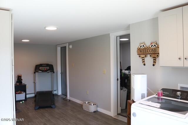 kitchen with washer / clothes dryer, baseboard heating, wood finished floors, and white cabinetry