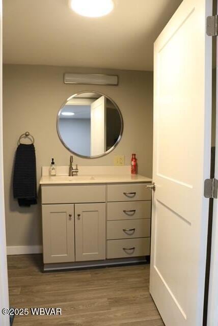 bathroom with wood finished floors, vanity, and baseboards