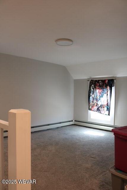 empty room with vaulted ceiling and carpet flooring