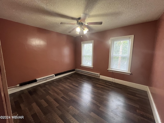 unfurnished room with baseboard heating, ceiling fan, dark wood-type flooring, and a textured ceiling