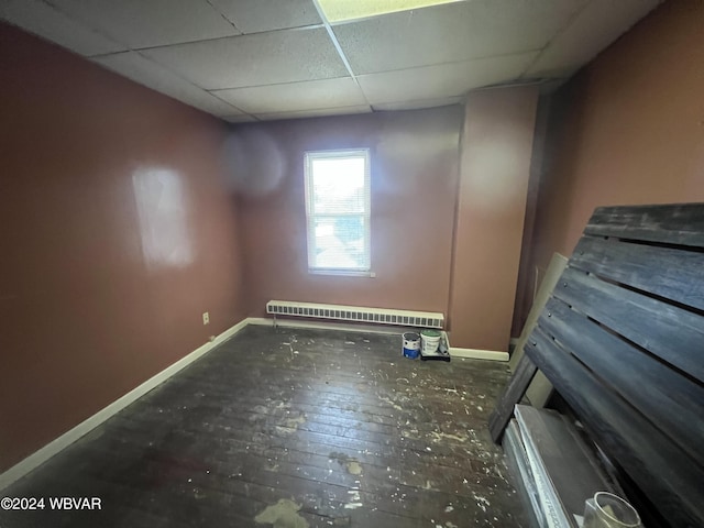 unfurnished room featuring dark hardwood / wood-style floors and a drop ceiling