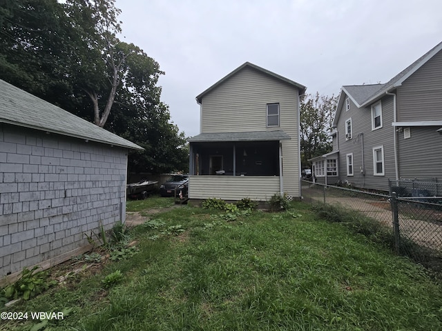 back of property featuring a sunroom and a yard