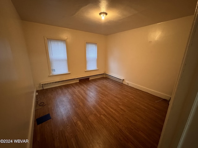 spare room featuring dark hardwood / wood-style floors and baseboard heating