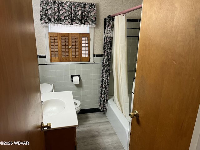 full bathroom featuring vanity, shower / bath combination with curtain, hardwood / wood-style flooring, toilet, and tile walls