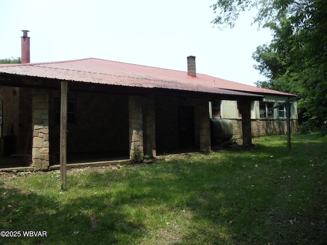 5801 N Rt 220th Hwy, Linden, PA 17744 - rear view of house with heating fuel, stone siding, a lawn, and metal roof