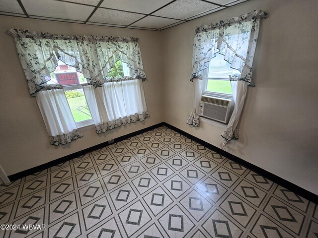 unfurnished room featuring a paneled ceiling and cooling unit