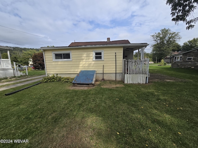 rear view of house featuring a lawn