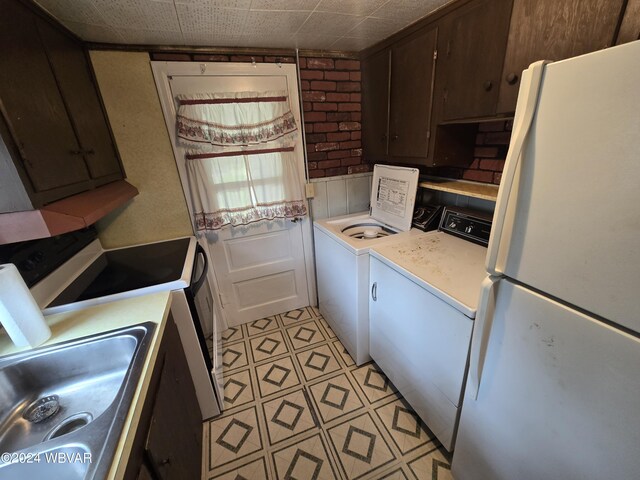 kitchen featuring dark brown cabinetry, sink, separate washer and dryer, stainless steel stove, and white fridge