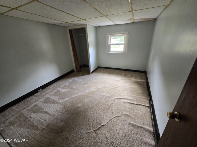 carpeted spare room with a drop ceiling