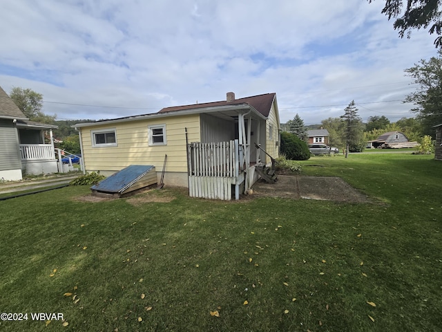 rear view of property featuring a lawn