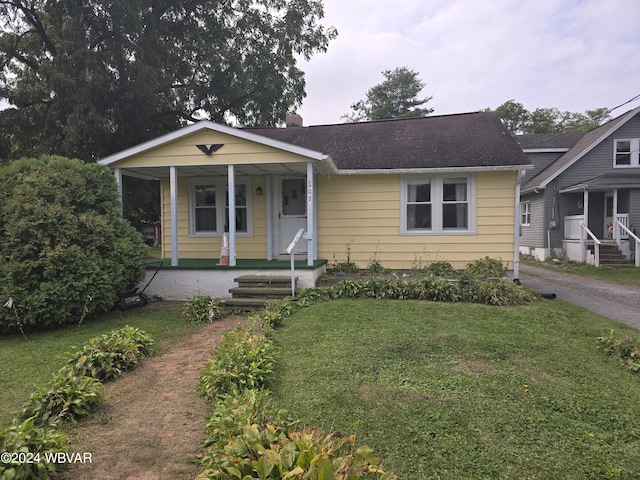 bungalow-style house featuring covered porch and a front yard