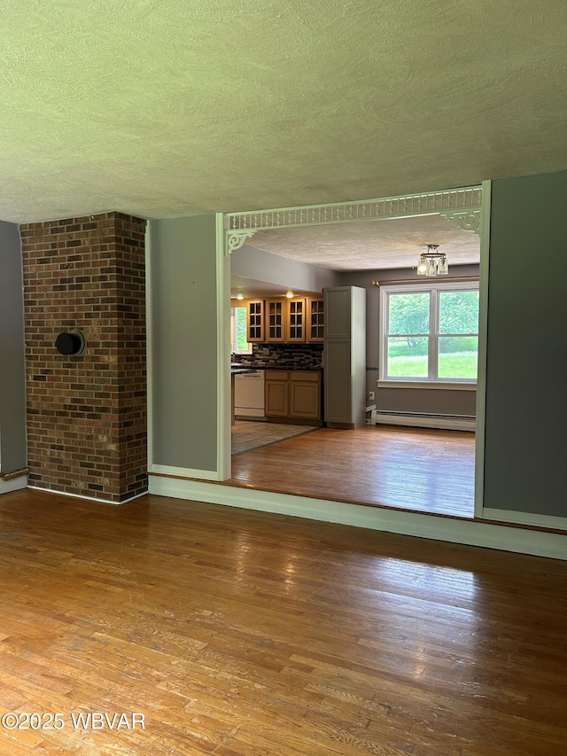 575 Steele Hill Rd, Sugar Run, PA 18846 - unfurnished living room with a textured ceiling, a baseboard radiator, wood finished floors, and baseboards