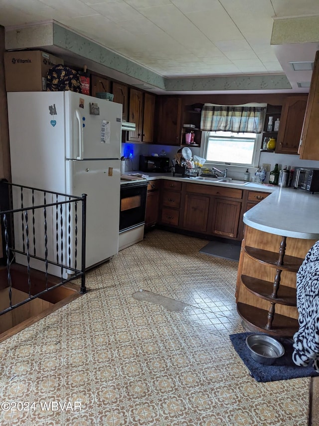 kitchen featuring range with electric cooktop, white refrigerator, extractor fan, and sink