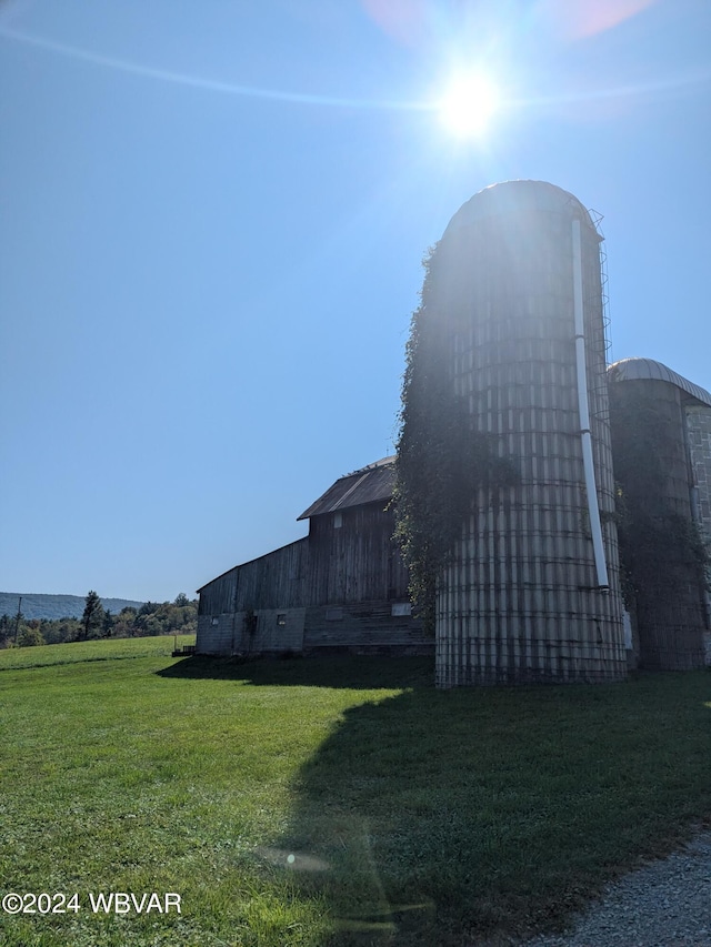 view of side of property with a lawn and an outbuilding