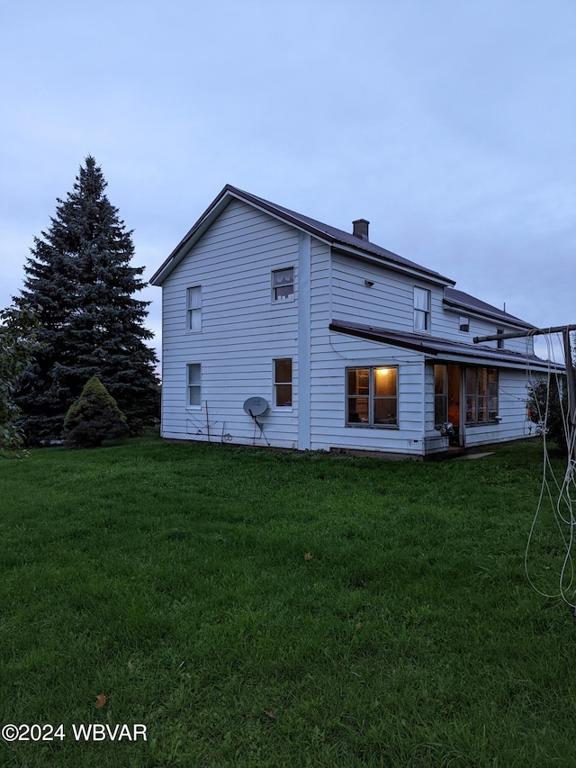 back of property featuring a lawn