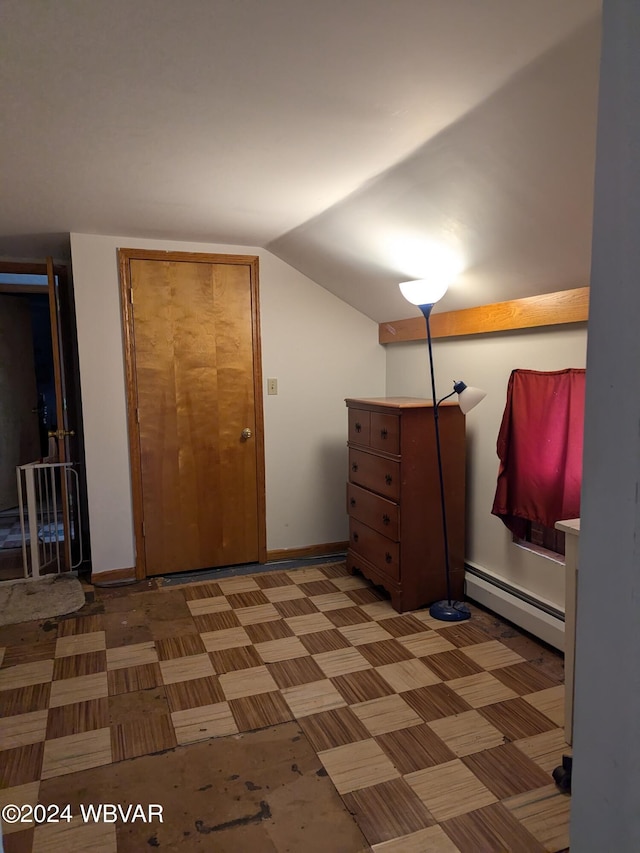 bedroom with vaulted ceiling and a baseboard heating unit