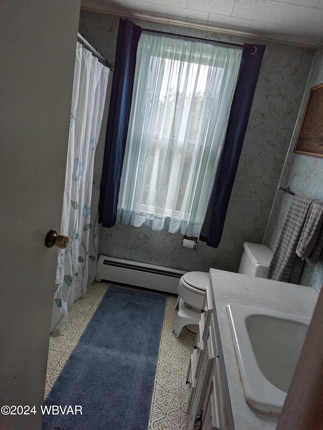 bathroom with curtained shower, a baseboard heating unit, tile patterned floors, toilet, and vanity