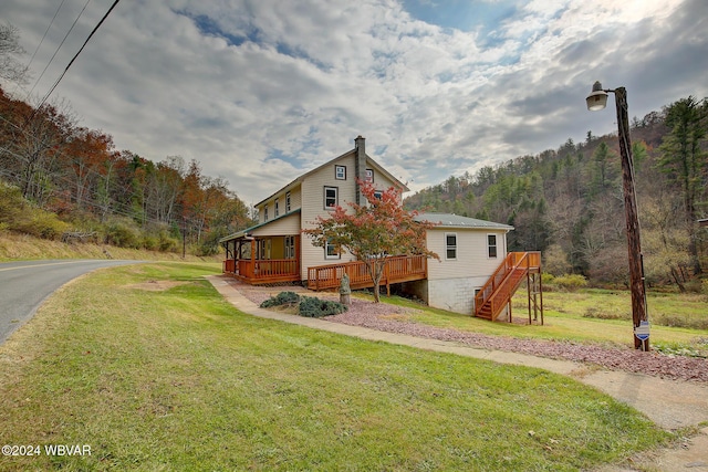 view of side of property with a deck and a yard