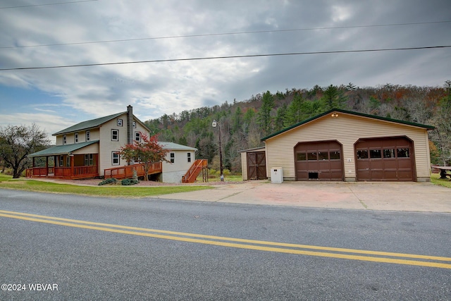 view of front of house featuring a deck, a garage, and an outdoor structure