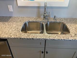 details featuring a sink, light stone counters, and gray cabinets