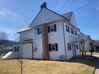 view of side of property with a lawn and a chimney