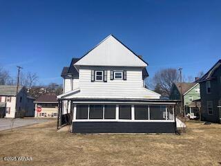 back of property with a sunroom