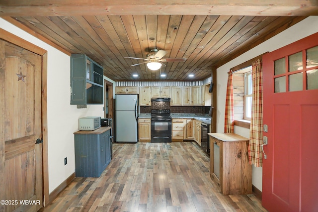 4792 Muncy Exchange Rd, Turbotville, PA 17772 - kitchen with black electric range, freestanding refrigerator, under cabinet range hood, dishwashing machine, and light wood-style floors