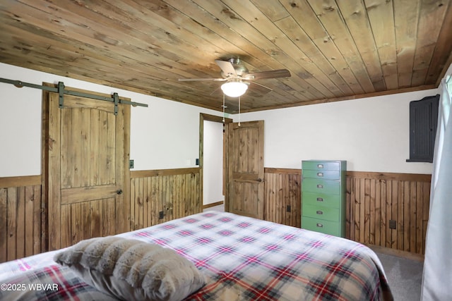 4792 Muncy Exchange Rd, Turbotville, PA 17772 - bedroom with wainscoting, wood walls, wooden ceiling, a barn door, and carpet floors