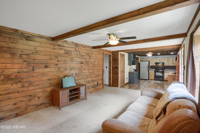 4792 Muncy Exchange Rd, Turbotville, PA 17772 - living room with wood walls, beamed ceiling, light colored carpet, and ceiling fan