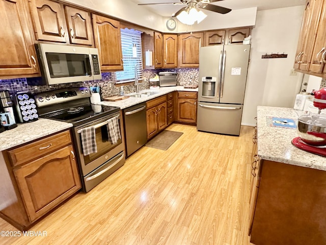 15 Hillview Ave, Williamsport, PA 17701 - kitchen featuring stainless steel appliances, a sink, a ceiling fan, decorative backsplash, and brown cabinets