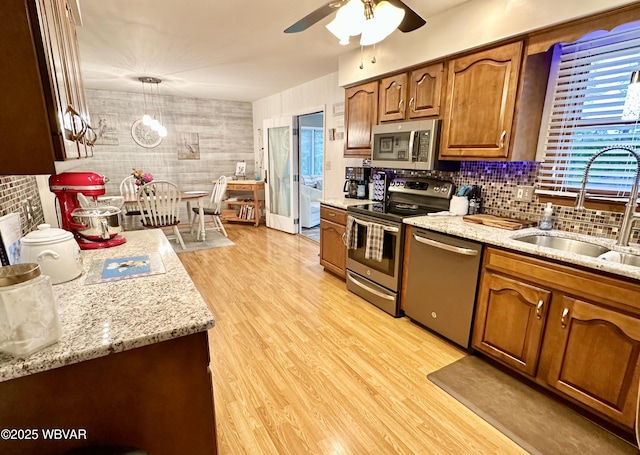 15 Hillview Ave, Williamsport, PA 17701 - kitchen with stainless steel appliances, a sink, ceiling fan, brown cabinetry, and light wood finished floors