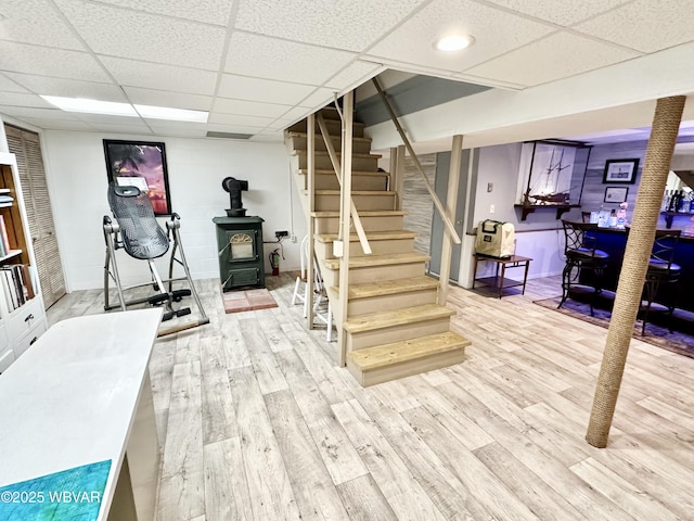 15 Hillview Ave, Williamsport, PA 17701 - finished basement with wood finished floors, a paneled ceiling, stairs, a wood stove, and baseboards