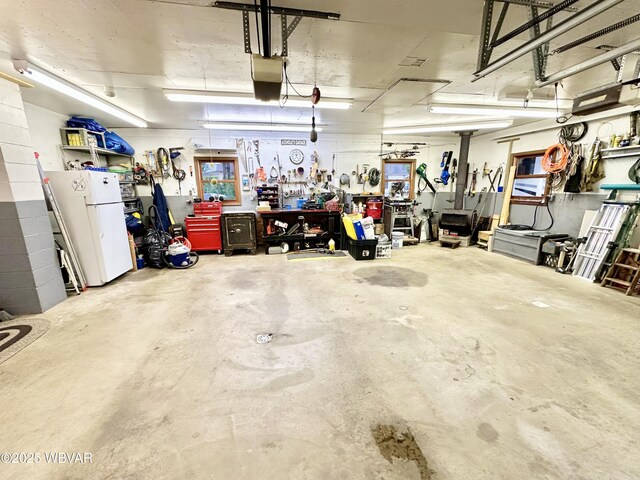 15 Hillview Ave, Williamsport, PA 17701 - garage with a workshop area, freestanding refrigerator, and a garage door opener