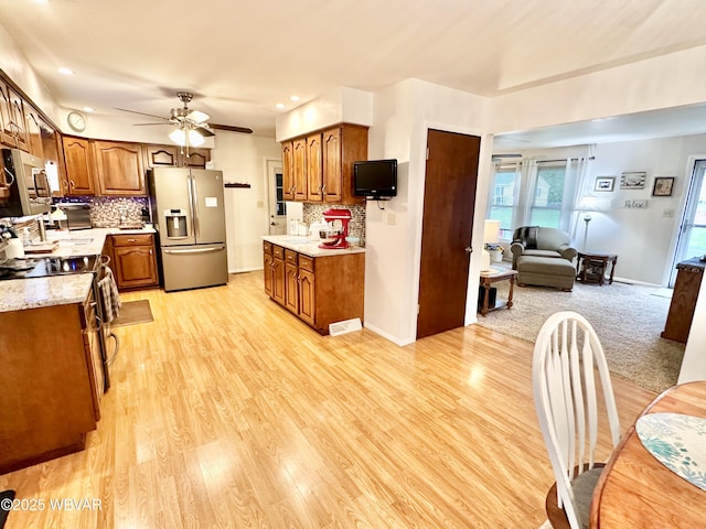 15 Hillview Ave, Williamsport, PA 17701 - kitchen featuring appliances with stainless steel finishes, brown cabinets, light countertops, ceiling fan, and backsplash