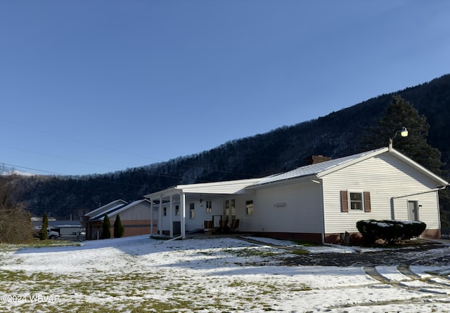 view of snowy exterior with a mountain view