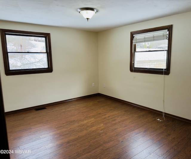 unfurnished room with dark hardwood / wood-style floors and plenty of natural light