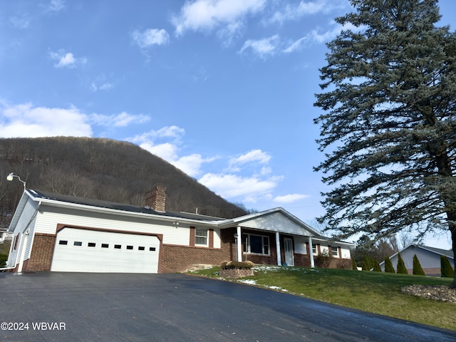 view of front of house featuring a mountain view, a front lawn, and a garage