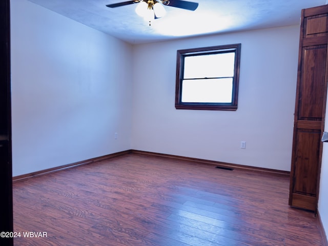 spare room with ceiling fan and dark hardwood / wood-style flooring