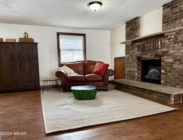 living room with hardwood / wood-style flooring and a brick fireplace