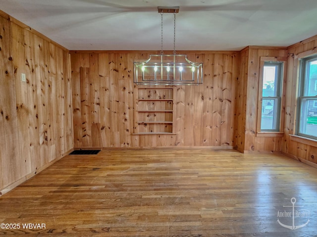 402 N Lincoln Ave, Jersey Shore, PA 17740 - unfurnished dining area featuring wood finished floors, wood walls, and a chandelier