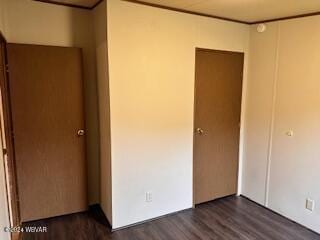 unfurnished bedroom with a closet and dark wood-type flooring