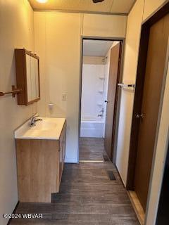 bathroom with wood-type flooring, vanity, and shower / bathtub combination