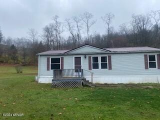 view of front of house featuring a wooden deck and a front lawn