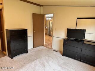 carpeted bedroom with stainless steel fridge and crown molding